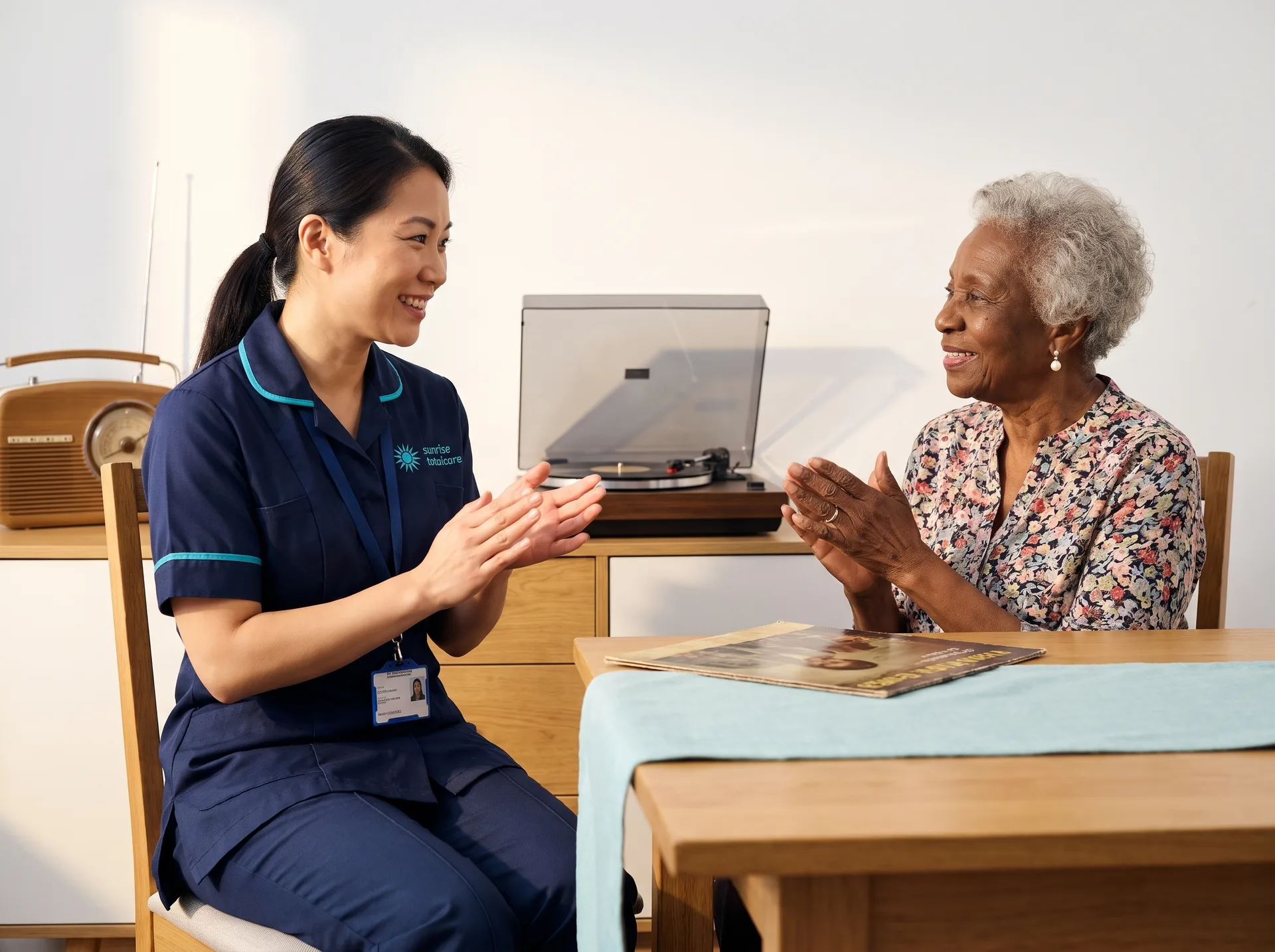 Trained dementia carer enjoying familiar music with an older woman at home in Bedfordshire