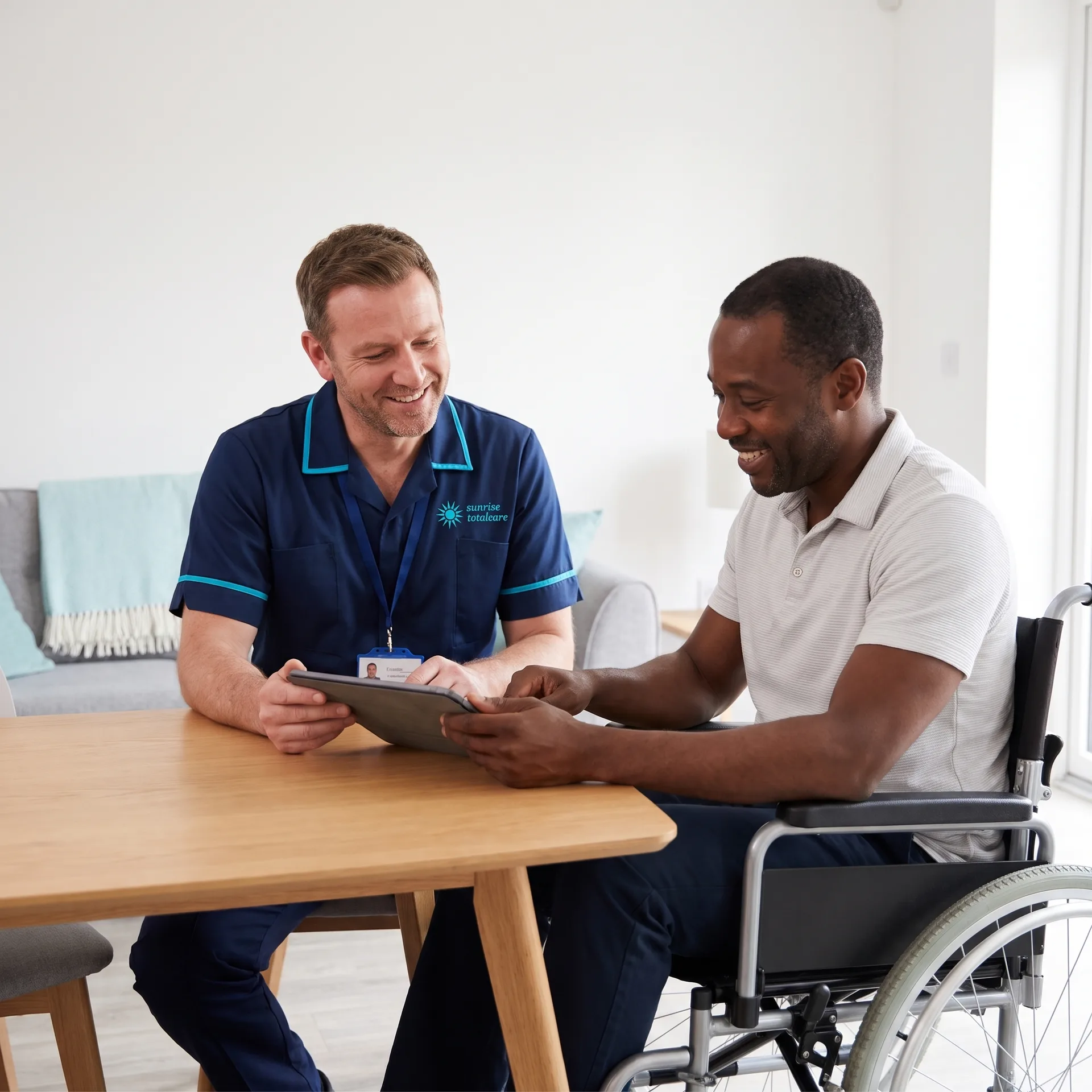 Carer and a man who uses a wheelchair planning his week together, showing home care for adults with disabilities